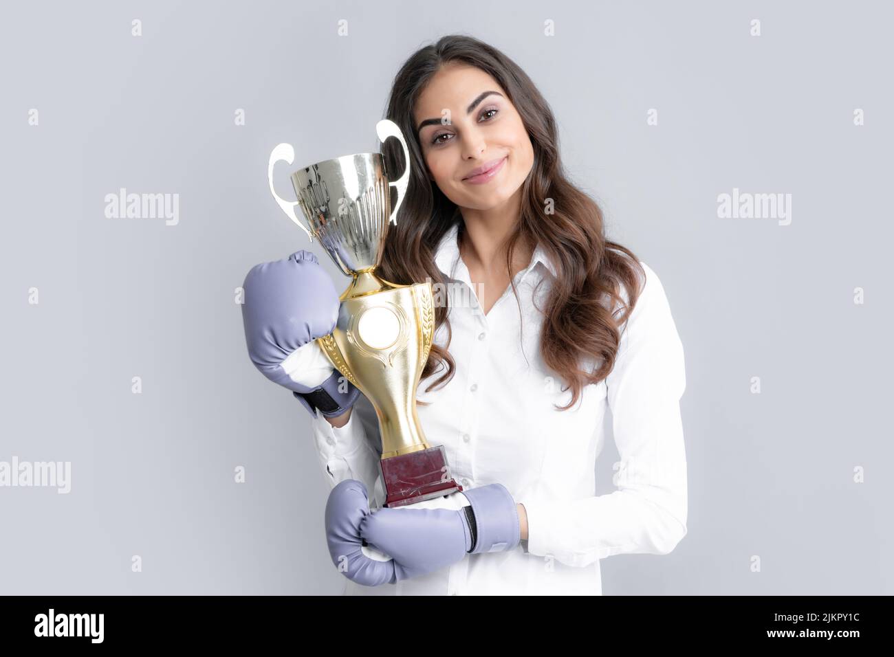Woman in boxing gloves hold champion winner cup, trophy. Strong powerful girl, competition concept. Stock Photo