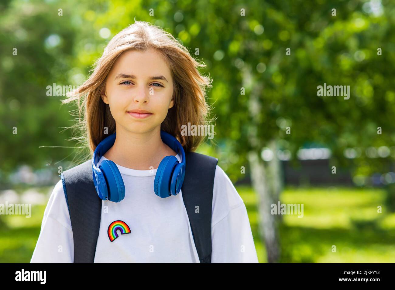 teen age girl with backpack and headset in park back to school concept Stock Photo