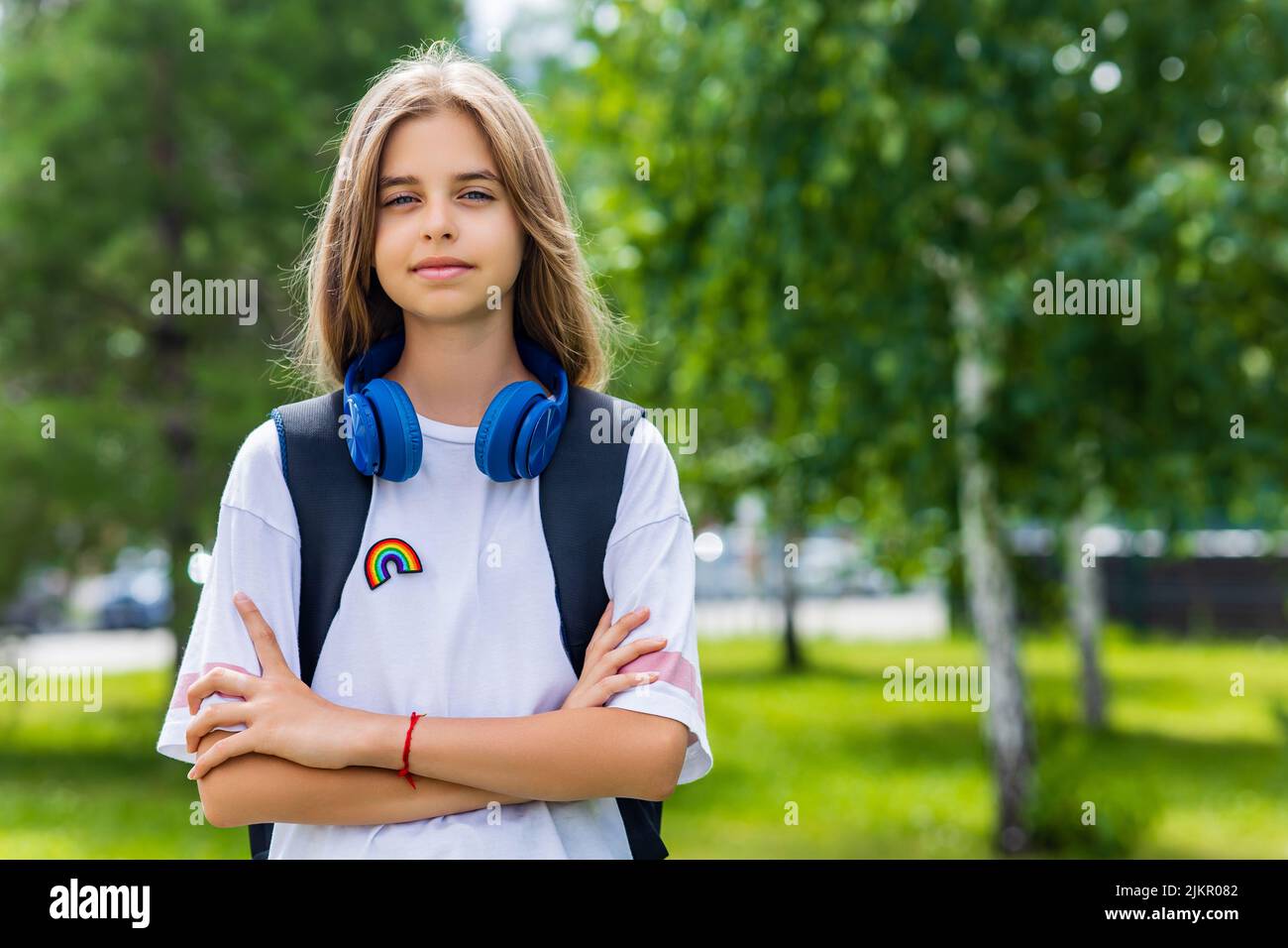 teen age girl with backpack and headset in park back to school concept Stock Photo