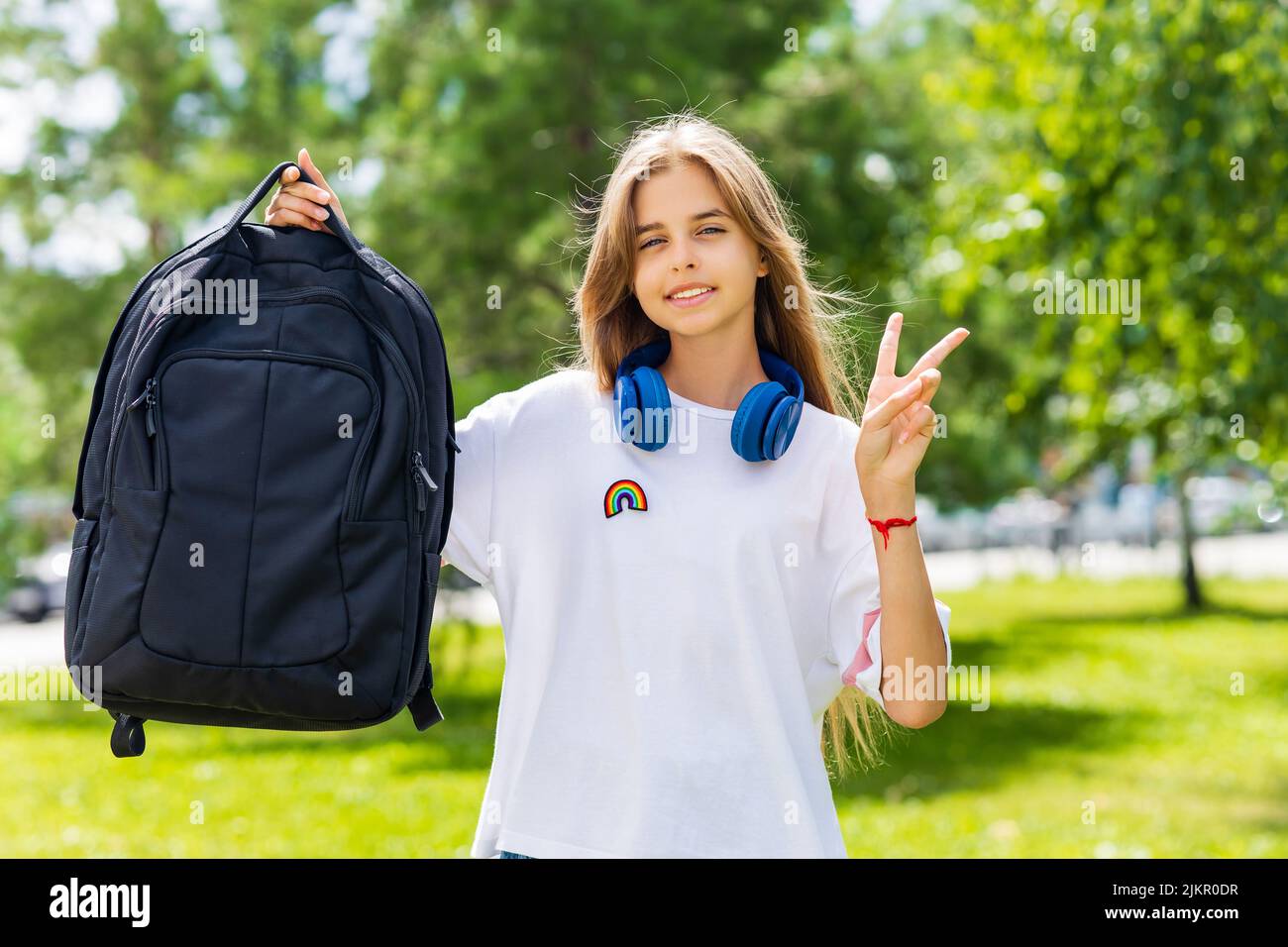 girl in white t-shirt with backpack going to school Stock Photo