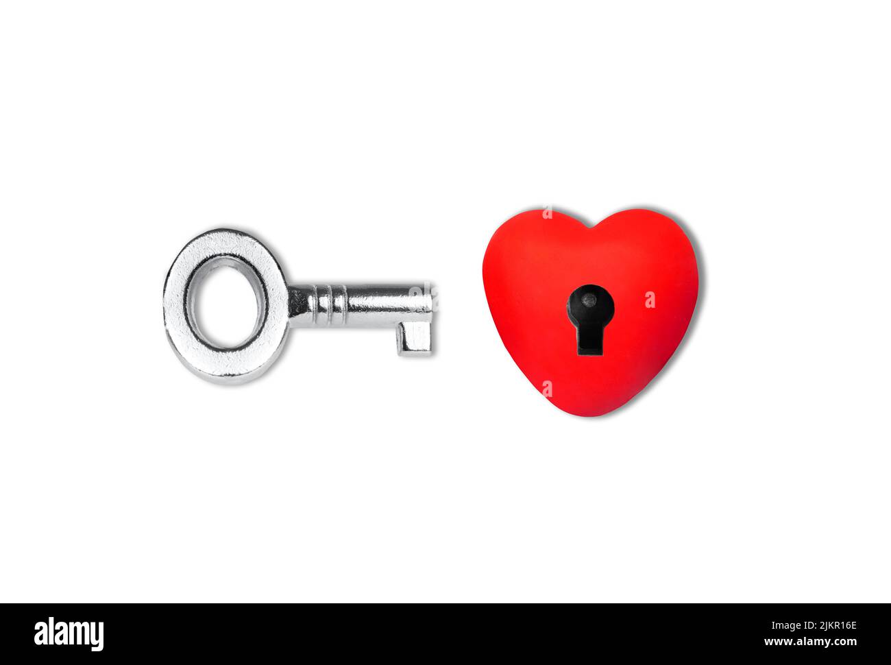 Heart shape with a keyhole and a silver-toned skeleton key isolated on white background. Romantic concept. Stock Photo
