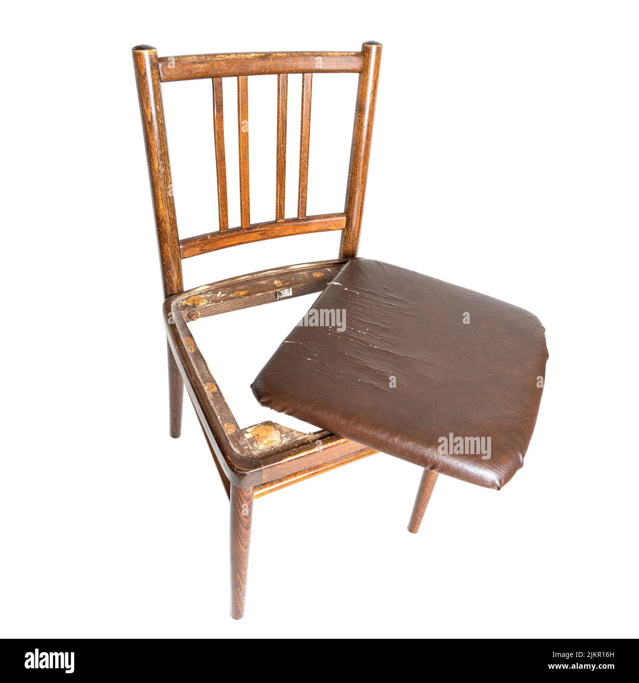 Old and broken dining chair with a shabby cracked seat isolated on white background Stock Photo