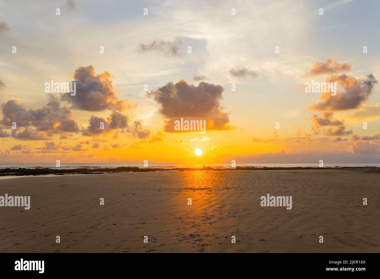 Scenic cloudscape over a tropical beach at sunset. Stock Photo