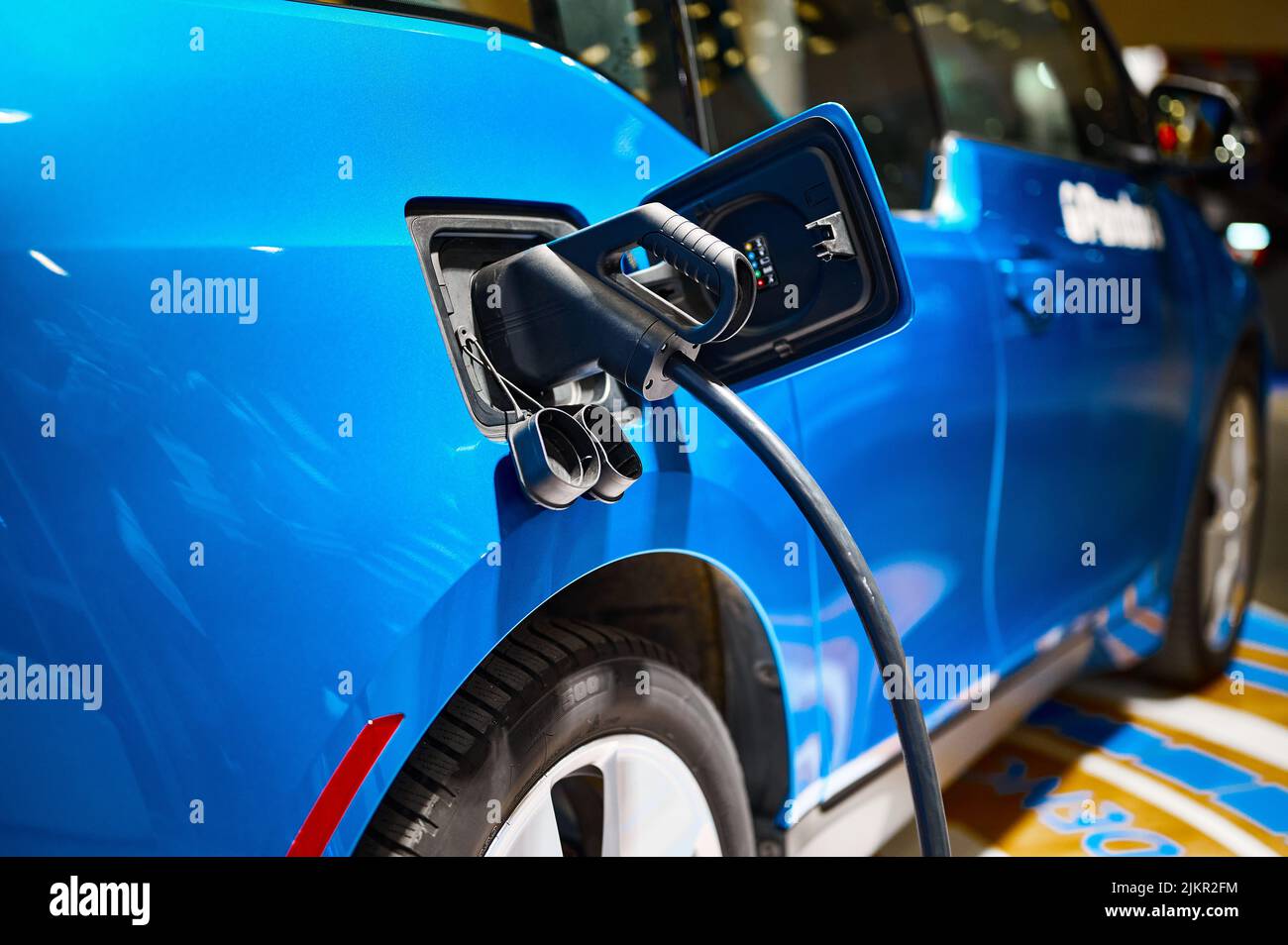 Charging electric automobile with plug at power station Stock Photo