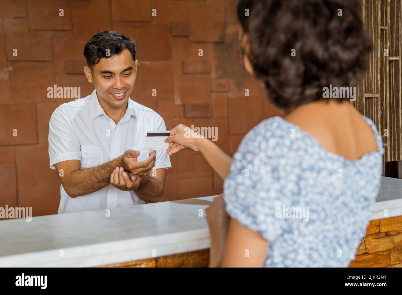 The receptionist accepts credit card payments from female guests Stock