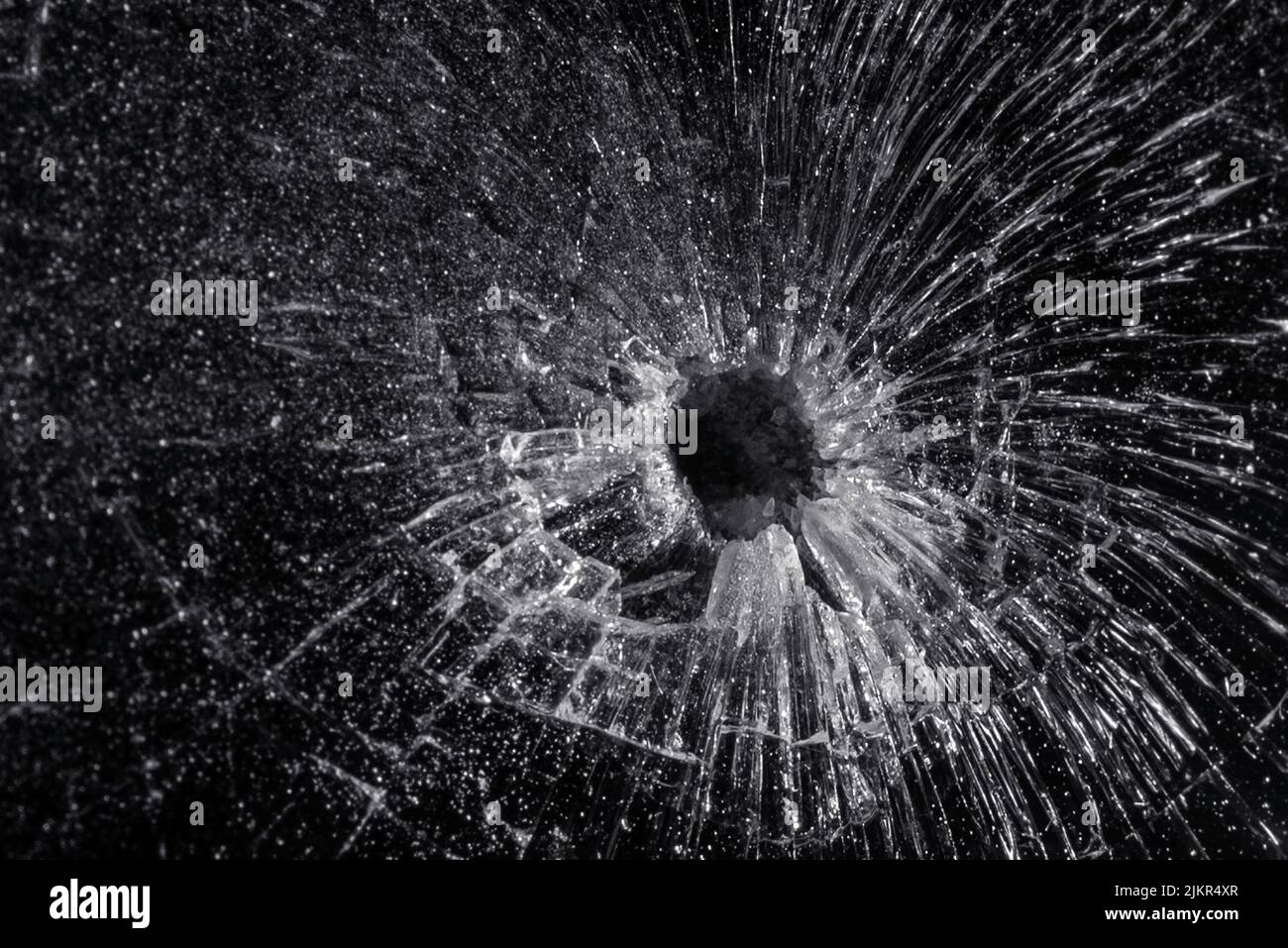 Bullet hole in a glass on the black background.closeup. Stock Photo