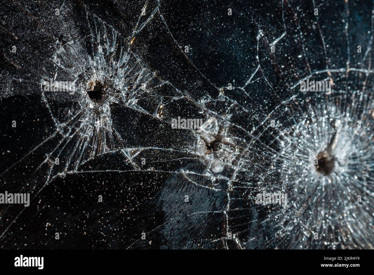 Bullet hole in a glass on the black background.closeup. Stock Photo