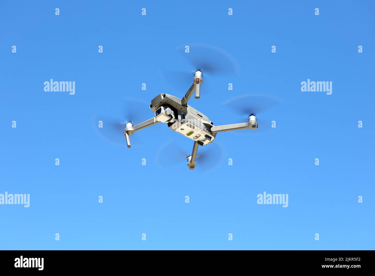 DJI Mavic drone in the air against a blue sky Stock Photo