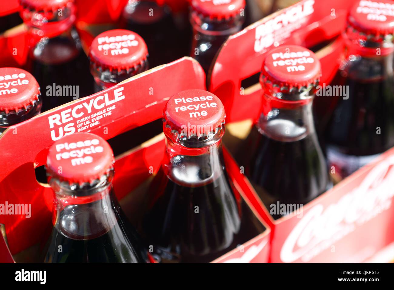 Coke bottles with Coca-Cola urging to recycle, bottles, caps and cardboard containers Stock Photo