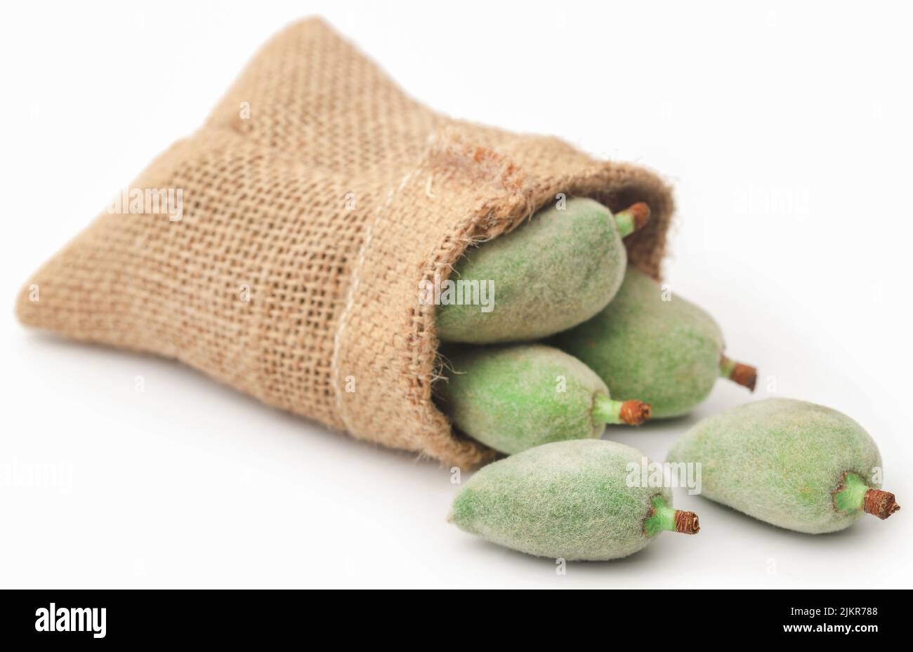 Green almond in jute sac over white background Stock Photo