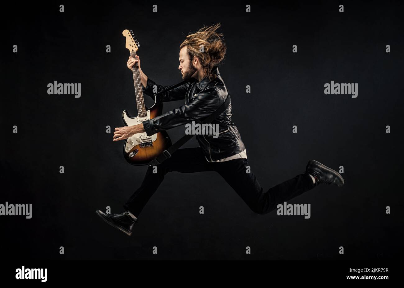 Alamy Rocker emotional bearded rocker in leather jacket. man long hair play electric ...