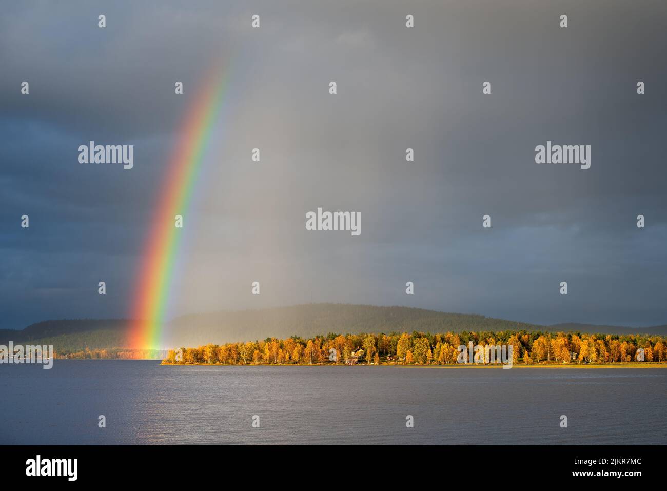 Rainbow over the autumn landscape, dramatic sky and light, forest trees in autumn colors. Lapland, Finland. Stock Photo