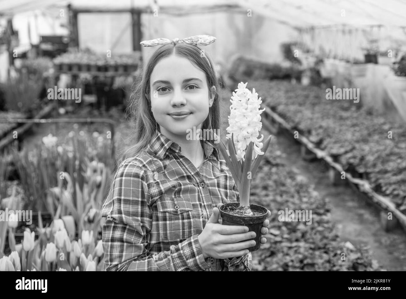 happy teen girl florist care pot plants in greenhouse, gardener Stock Photo