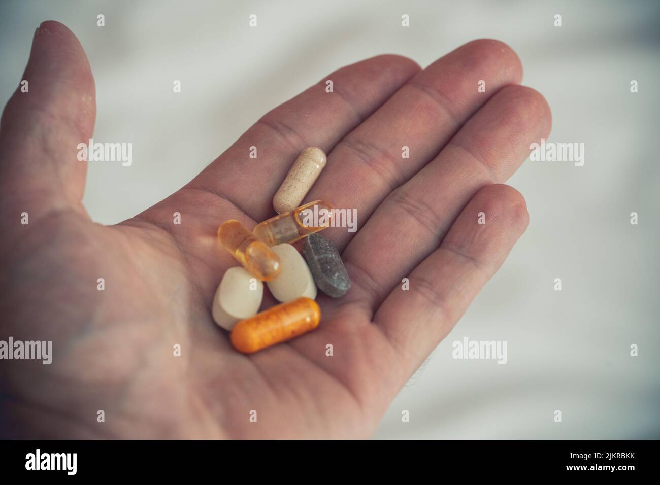 Many Colorful Pills, Tablets And Medicines Are Held In One Hand. Symbol Image Treatment Of Disease And Vitamin Dietary Supplement Stock Photo