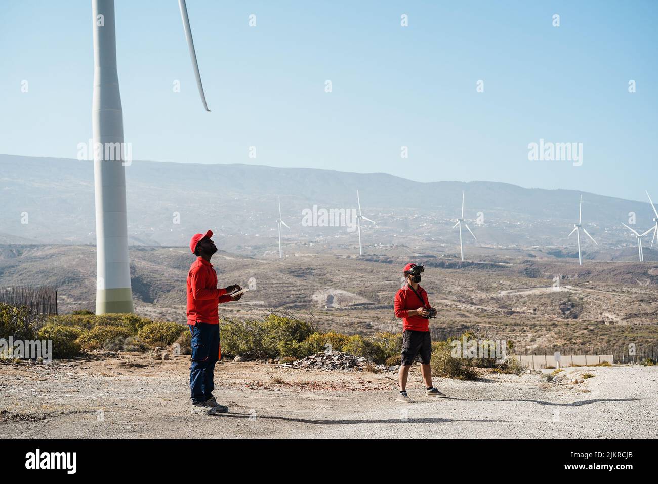 Multiracial engineer men using virtual reality headset on a windmill farm Stock Photo