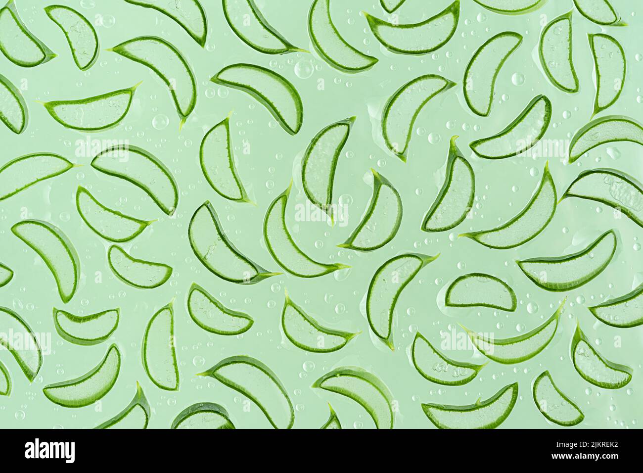 Pattern of aloe vera slices on green background. Top view Stock Photo