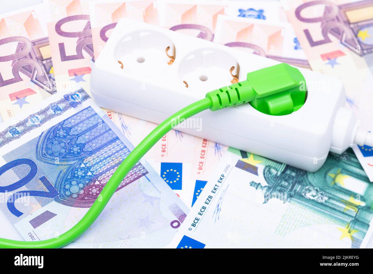 The photo shows a green power cable with euro banknotes Stock Photo