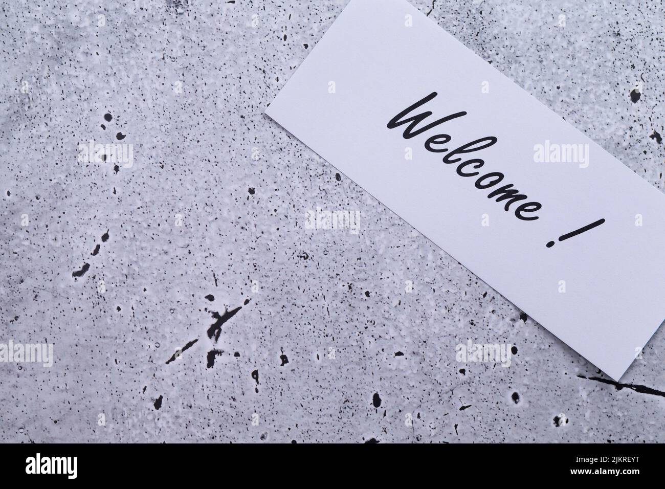 The photo shows a label with the inscription 'welcome' on a grey background Stock Photo