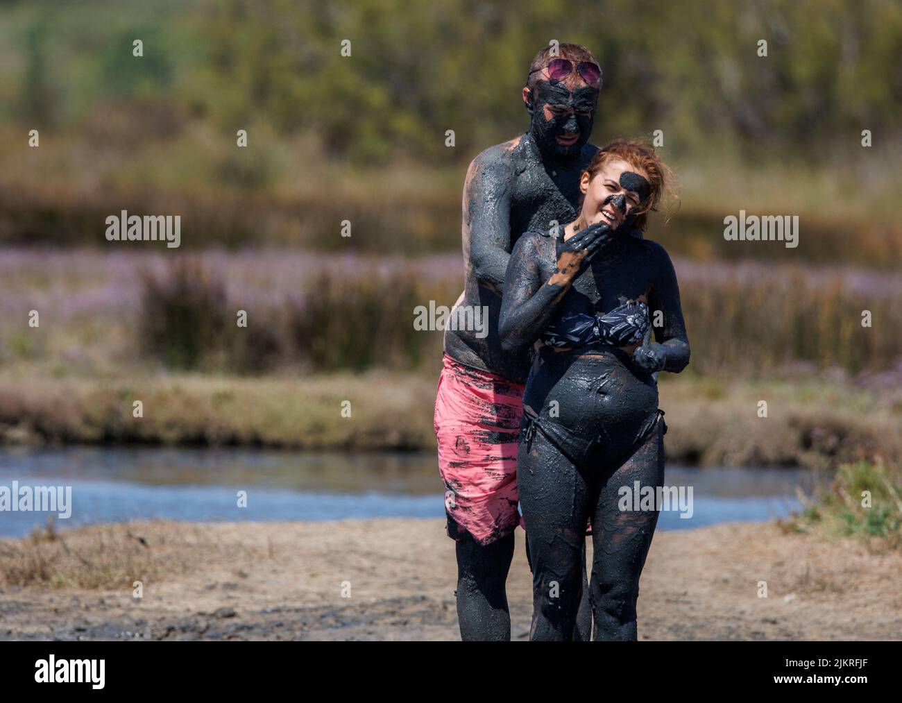 A couple smear themselves with mud that is believed to be curative at Queen's beach in Nin, Croatia, August 3, 2022. REUTERS/Antonio Bronic Stock Photo