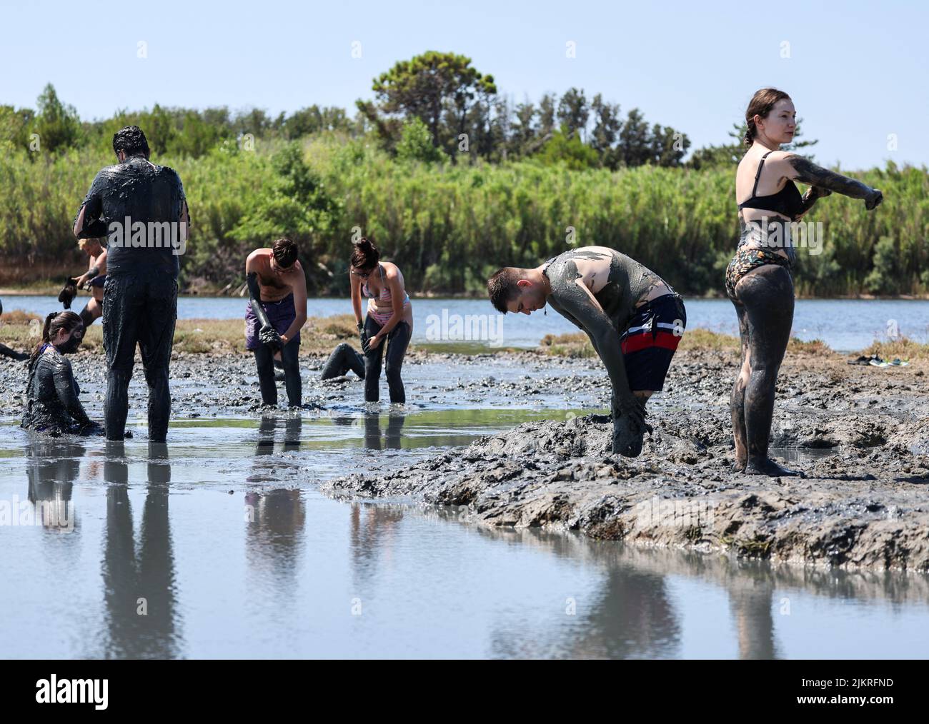 People smear themselves with mud that is believed to be curative at Queen's beach in Nin, Croatia, August 3, 2022. REUTERS/Antonio Bronic Stock Photo