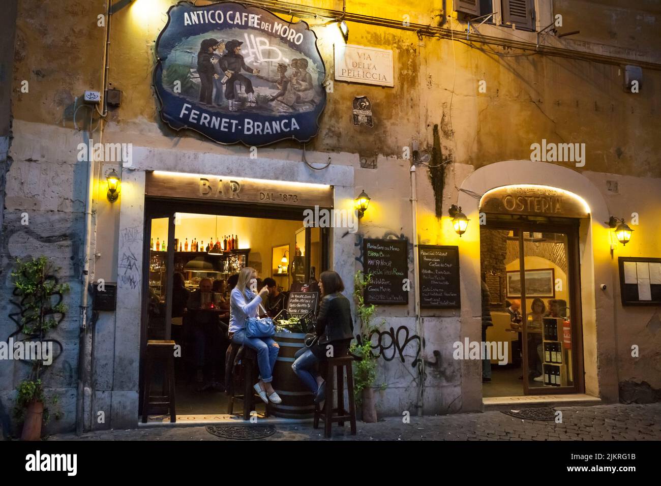 Two girls sitting on the Antico Caffe del Moro terrace in Trastevere, Rome Stock Photo
