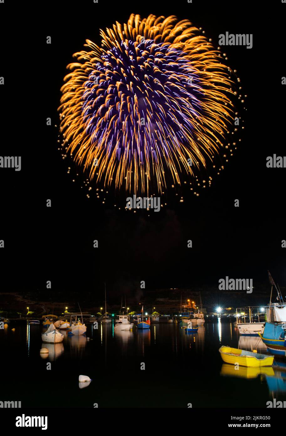 Marsaxlokk,Malta-Fireworks show,colorful fireworks on the black sky background with some boats under them during religion feast in Marsaxlokk fishing Stock Photo