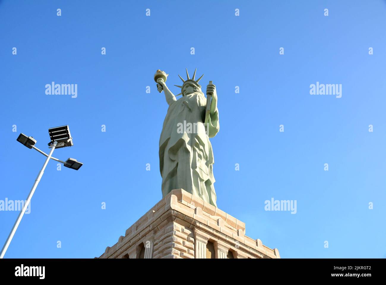 Imitation of the Statue of Liberty, on a concrete pedestal, led lamp post, blue sky in the background, Brazil, South America, bottom-up view Stock Photo