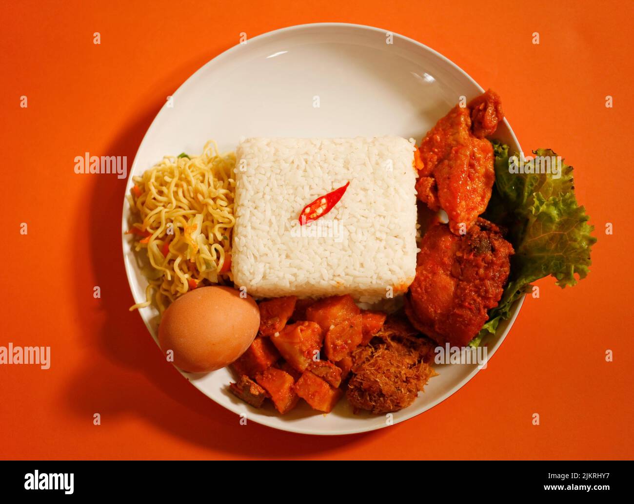 Rice Box or Indonesian lunch box with chicken meat, tofu, spicy potato, noddle, egg and vegetable Stock Photo