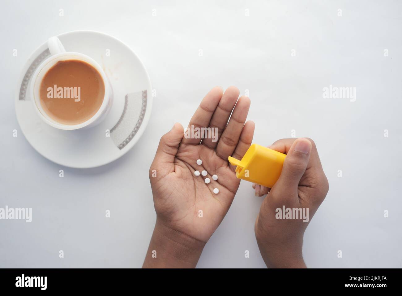young man putting artificial sweetener in tea, Stock Photo