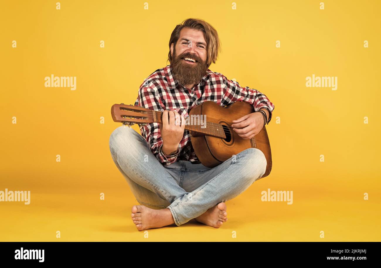his new song. relax with favorite music. guy with guitar performing song. Guitar player on yellow background. Cheerful guitarist. charismatic mature Stock Photo