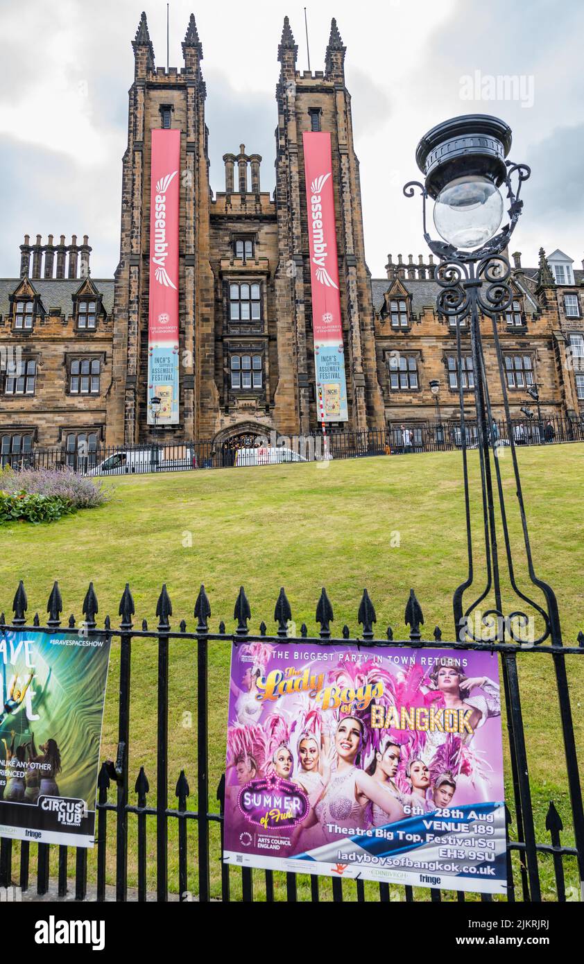 Edinburgh, Scotland, United Kingdom, 3rd August 2022. Edinburgh Festivals: Posters for the Edinburgh festival fringe shows in their usual place on the railings on The Mound with the Assembly Hall towers displaying festival banners and an old fashioned streetlight Stock Photo