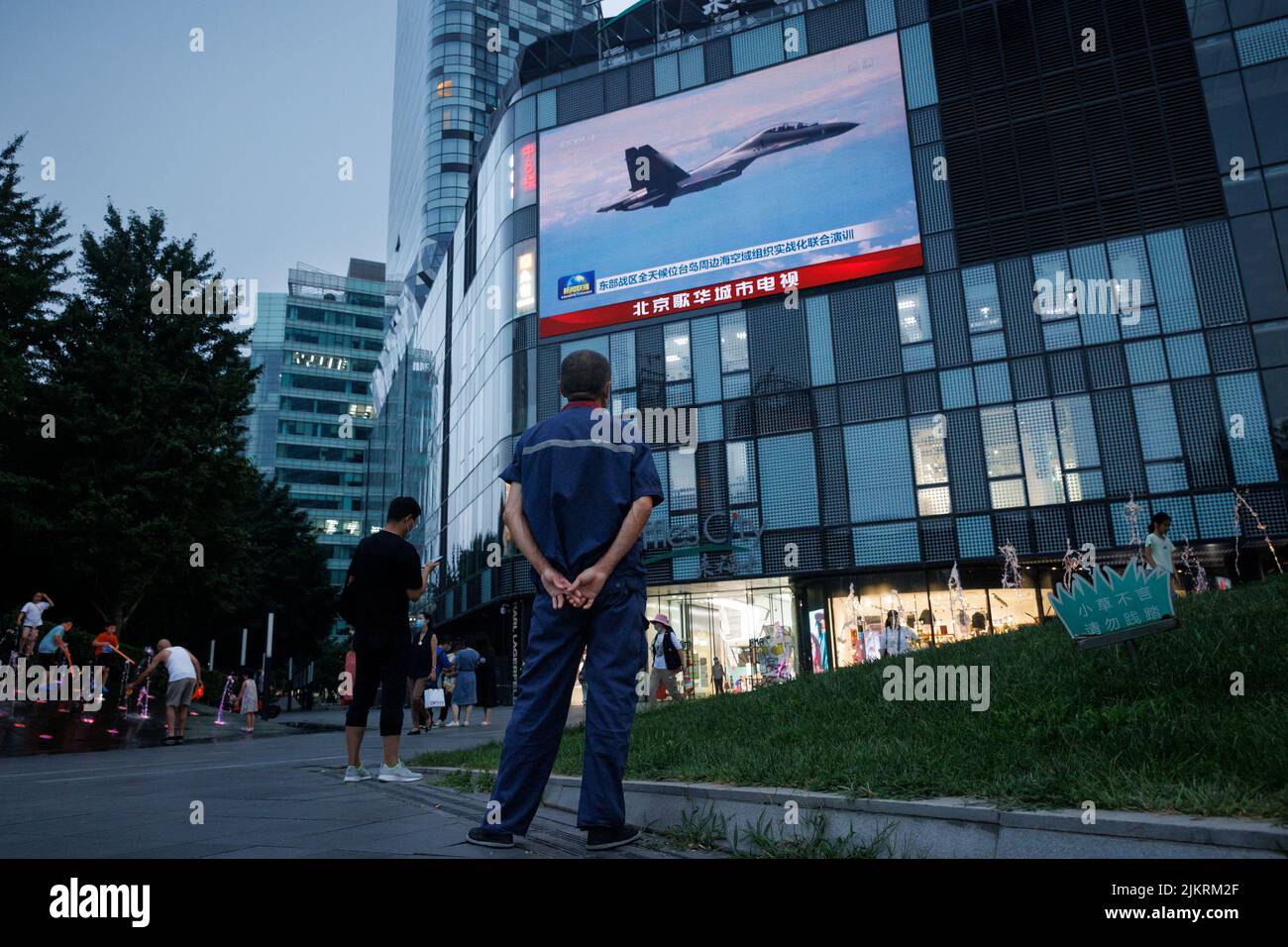 A man watches a CCTV news broadcast, showing a fighter jet during joint military operations near Taiwan by the Chinese People's Liberation Army's (PLA) Eastern Theatre Command, at a shopping center in Beijing, China, August 3, 2022. REUTERS/Thomas Peter Stock Photo