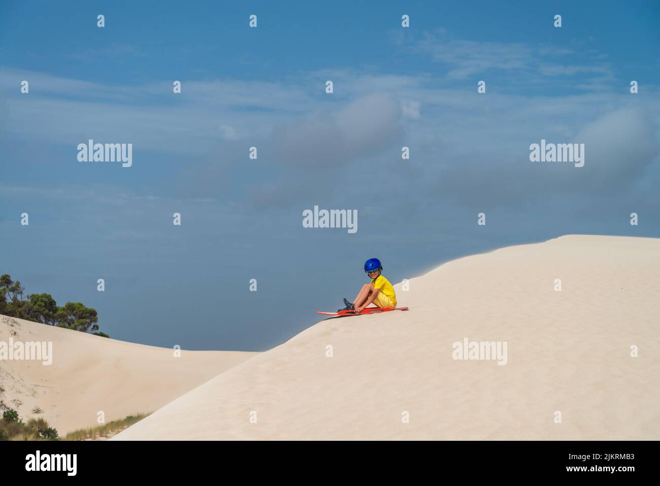 Boy is ready for sliding down the sand dune on sandboard, Kangaroo Island, South Australia Stock Photo