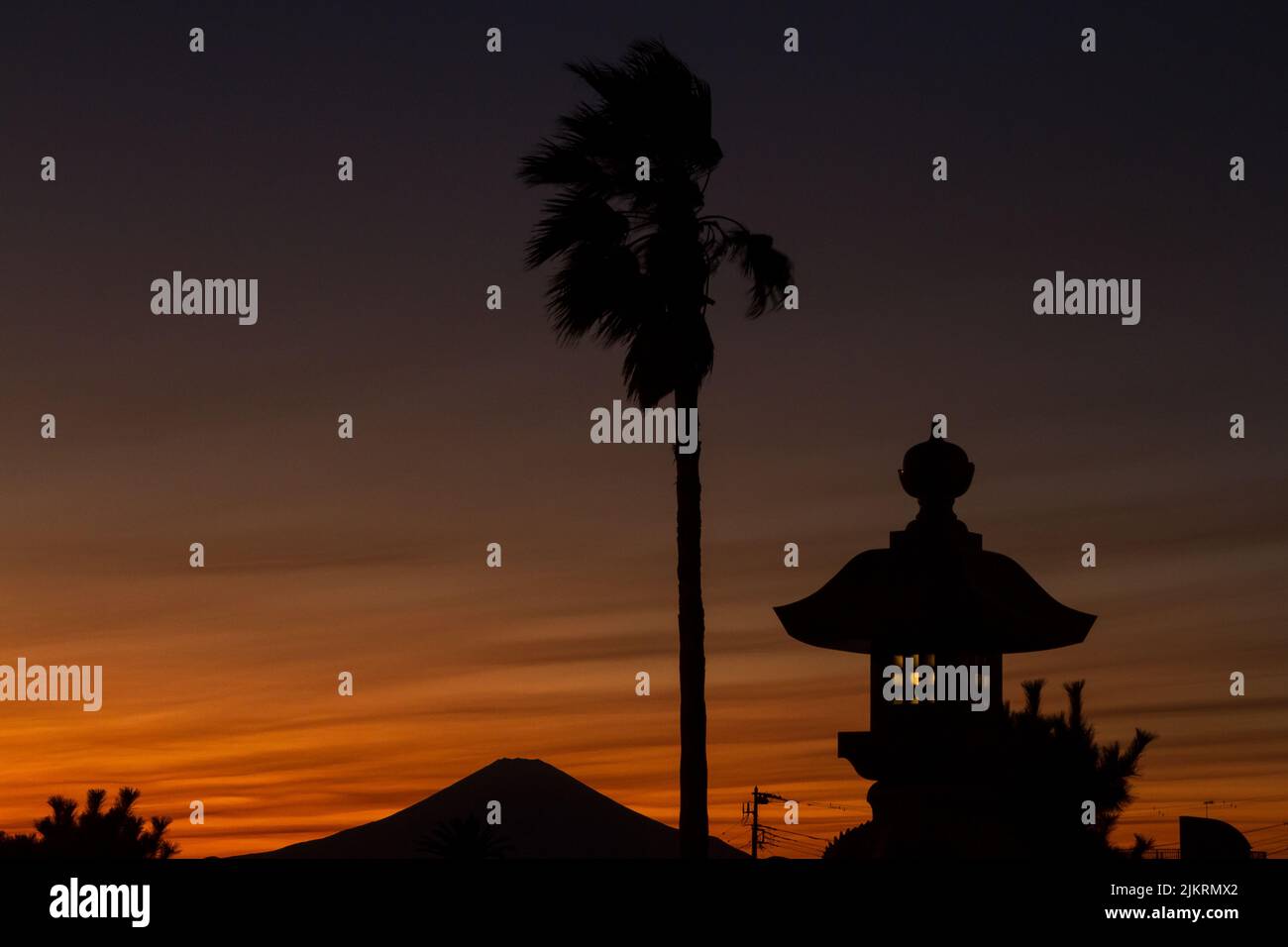 Mount Fuji, stone lanterns and palm trees at sunset. Enoshima, Kanagawa, Japan. Stock Photo