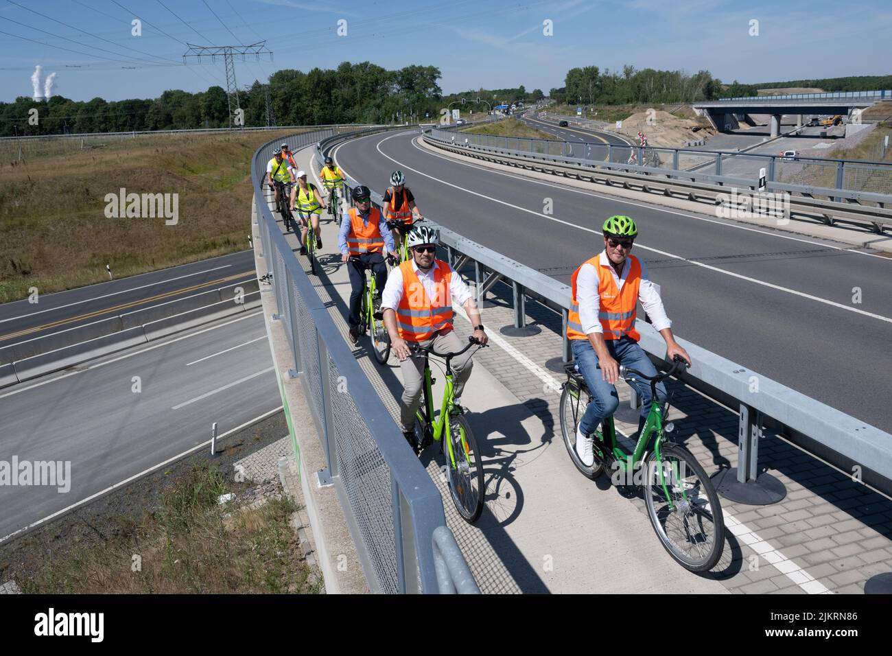 03 August 2022, Saxony, Rötha: Cyclists cross a bridge over highway 72 near Rötha. While the expansion of the last section of the A72 continues to progress, the B95 around Espenhain is currently being dismantled. A bike path is currently being built between Borna and Rötha, largely using existing lanes of the old B95 as a basis. Work on the centerpiece will continue until mid-October. Then the formerly very busy federal highway will become state road 242 with flanking green strips and space for pedestrians and cyclists. Photo: Hendrik Schmidt/dpa Stock Photo