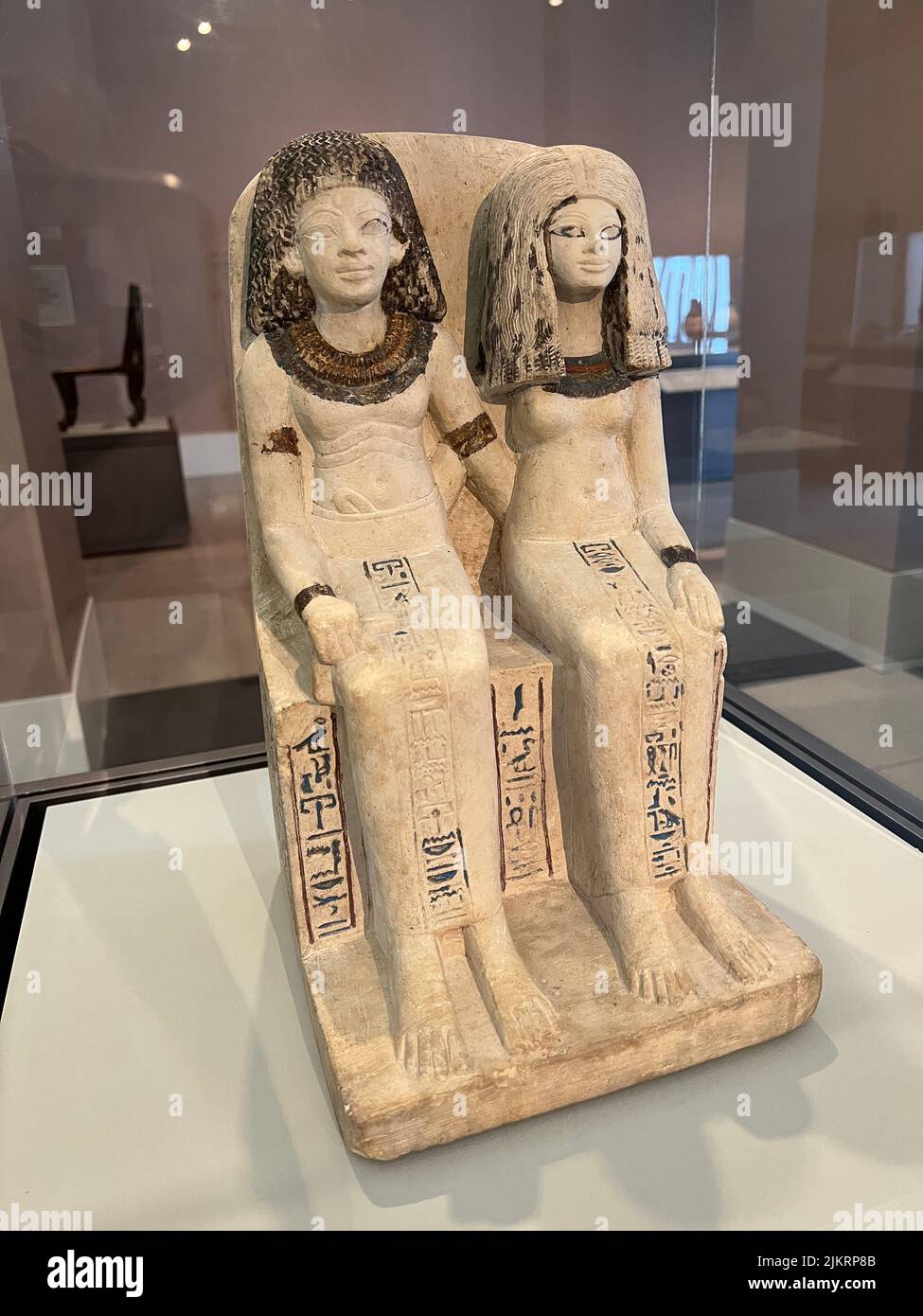 Pair Statue of Nebsen and Nebet-ta New Kingdom, Dynasty 18, reign of Thutmose IV or Amunhotep Ill, circa 1400-1352 B.C.E. Probably from Dahamsha Limestone, painted. Brooklyn Museum. To express the physical and spiritual bond between two individuals, sculptors devised a form called the pair statue. The most common variety showed the subjects-a husband and wife, a mother and child, or a king and a divinity, for example-seated together on a chair or bench. (BM) Stock Photo