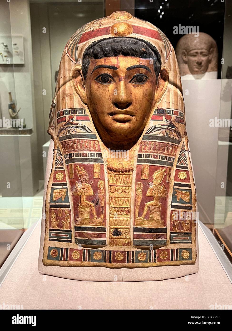 Mummy Mask of a Man, Stucco, gilded and painted, Roman Period, early 1st century C.E. Egypt:      Egyptian men living under Roman rule used mummy masks that combined contemporary and traditional elements. This example features locks of wavy black hair, a Roman fashion at this time. Stock Photo