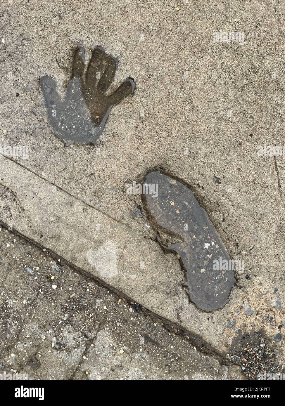 Foot and hand impression in a cement sidewalk in Brooklyn, New York, Stock Photo