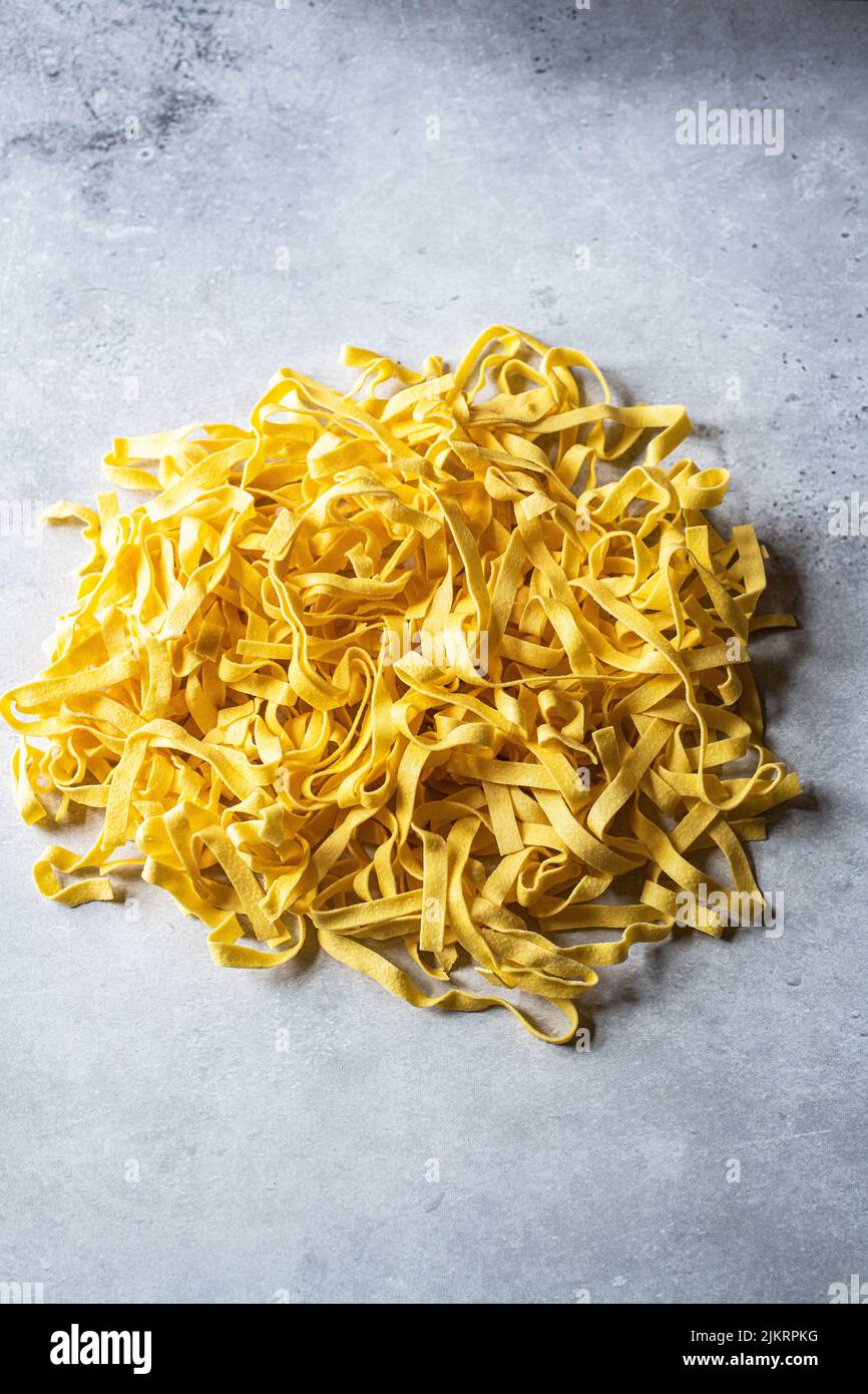 Raw uncooked pasta on a gray background. Stock Photo