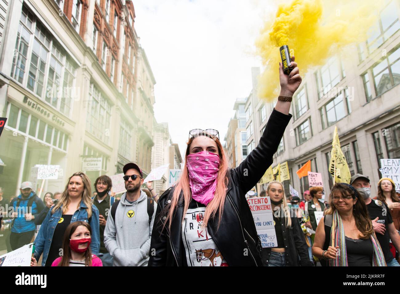 Animal rights activist leading march through London streets holding yellow flare 2021 Stock Photo