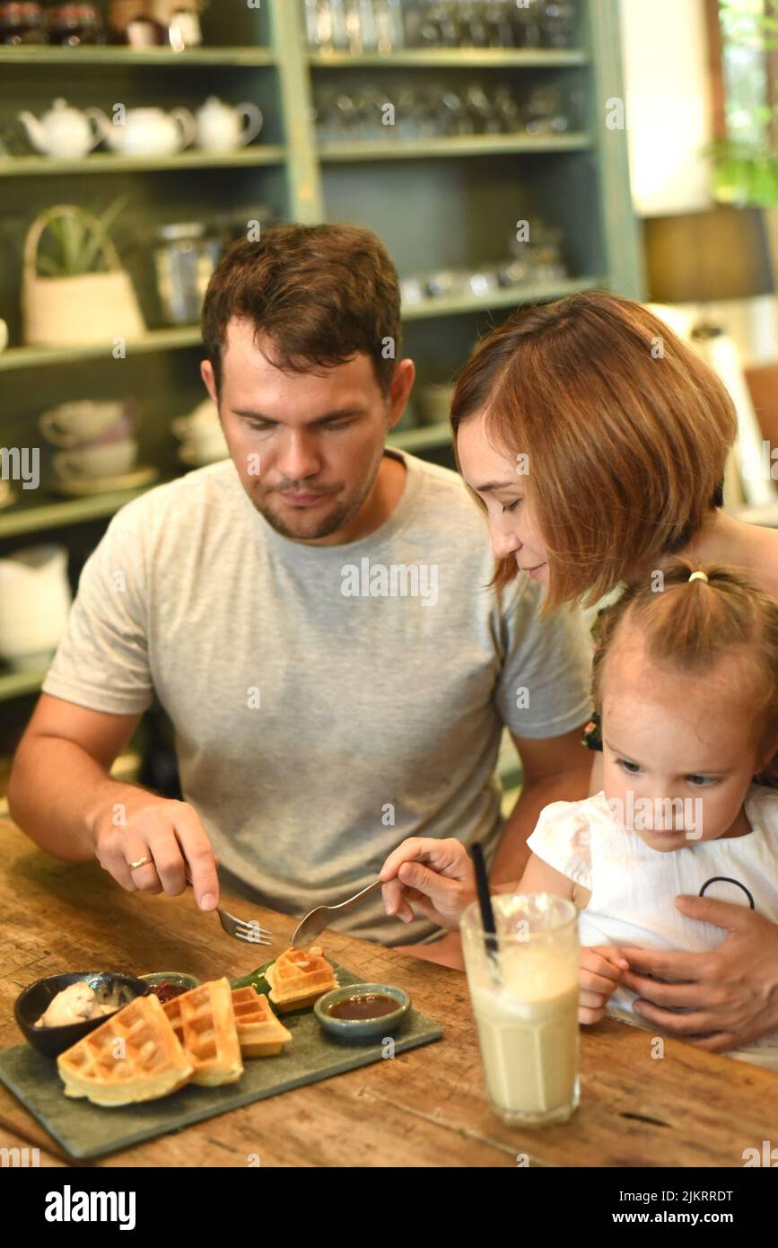Family eating Belgium waffles in a cafe Stock Photo Alamy