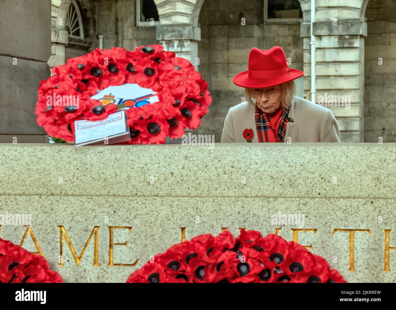 Senior lady looks at Poppy wreaths at the Stone of Remembrance, Edinburgh, on Remembrance Sunday, 2021. Stock Photo