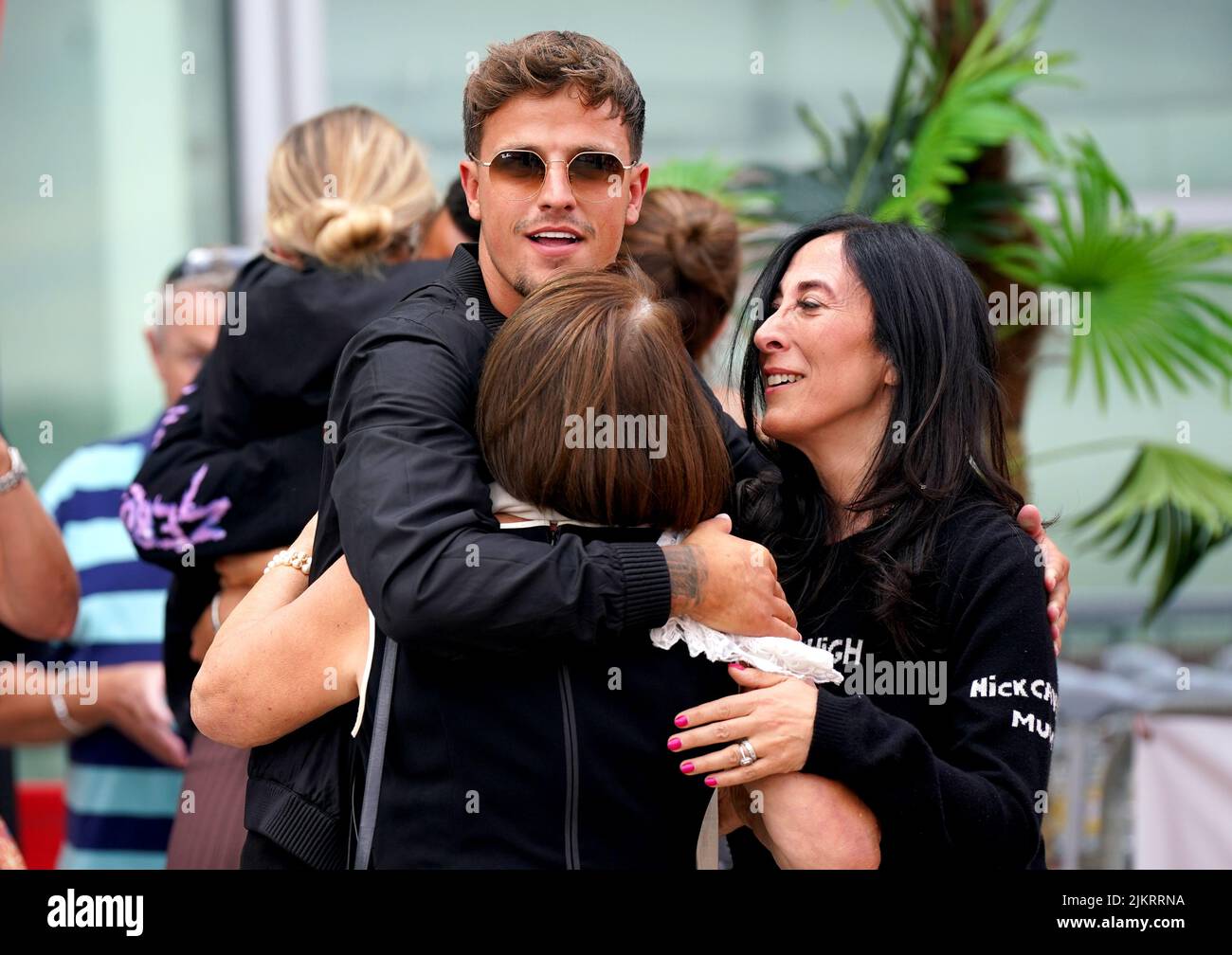 Love Island contestant Luca Bish hugs members of his family as he arrives at Stansted Airport in Essex. Picture date: Wednesday August 3, 2022. Stock Photo