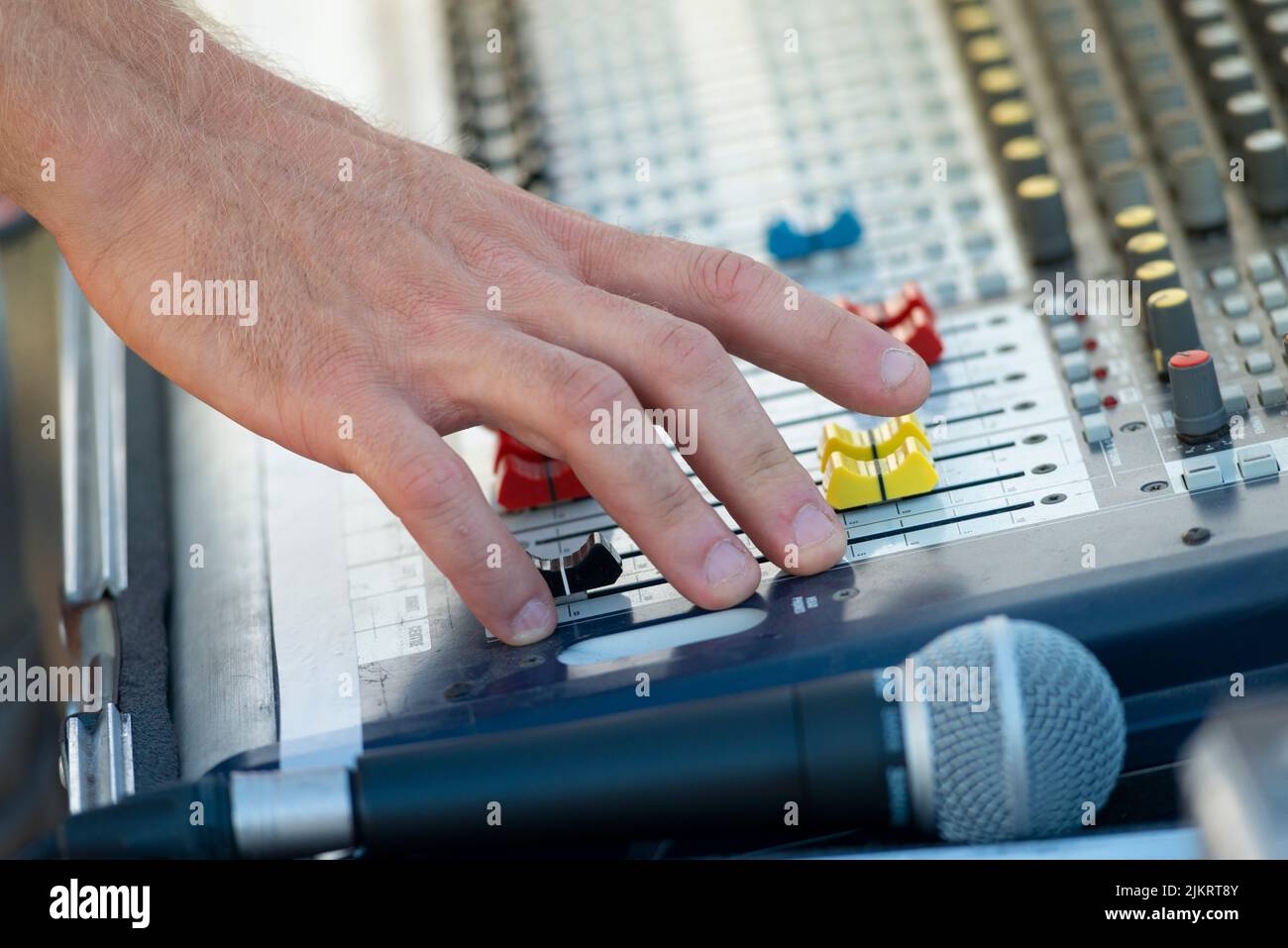 Sound Engineer Operating Professional Sound Mixer at Live Concert, Hand