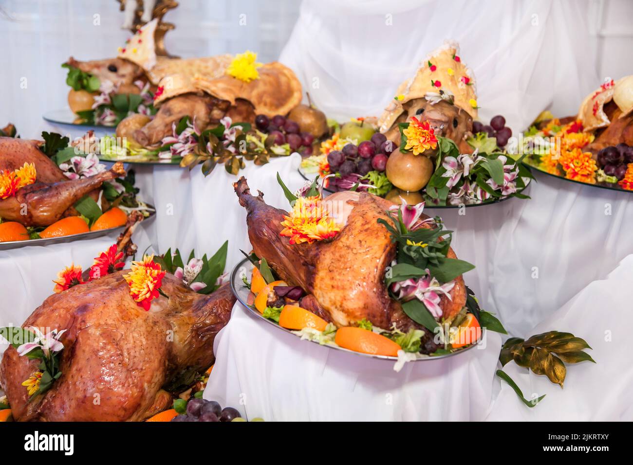 Buffet table with meat snacks, baked pigs in dough, cheese, turkey with
