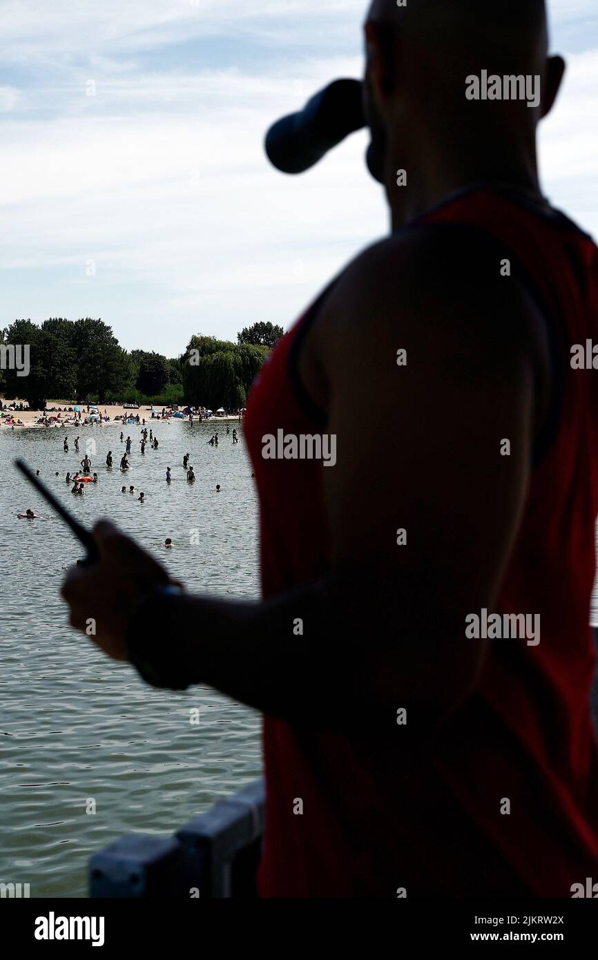 Berlin, Germany. 03rd Aug, 2022. A swimming supervisor observes bathing activities at the Wannsee lido. With temperatures around 33 degrees, many visitors are drawn to the outdoor pool. Credit: Carsten Koall/dpa/Alamy Live News Stock Photo