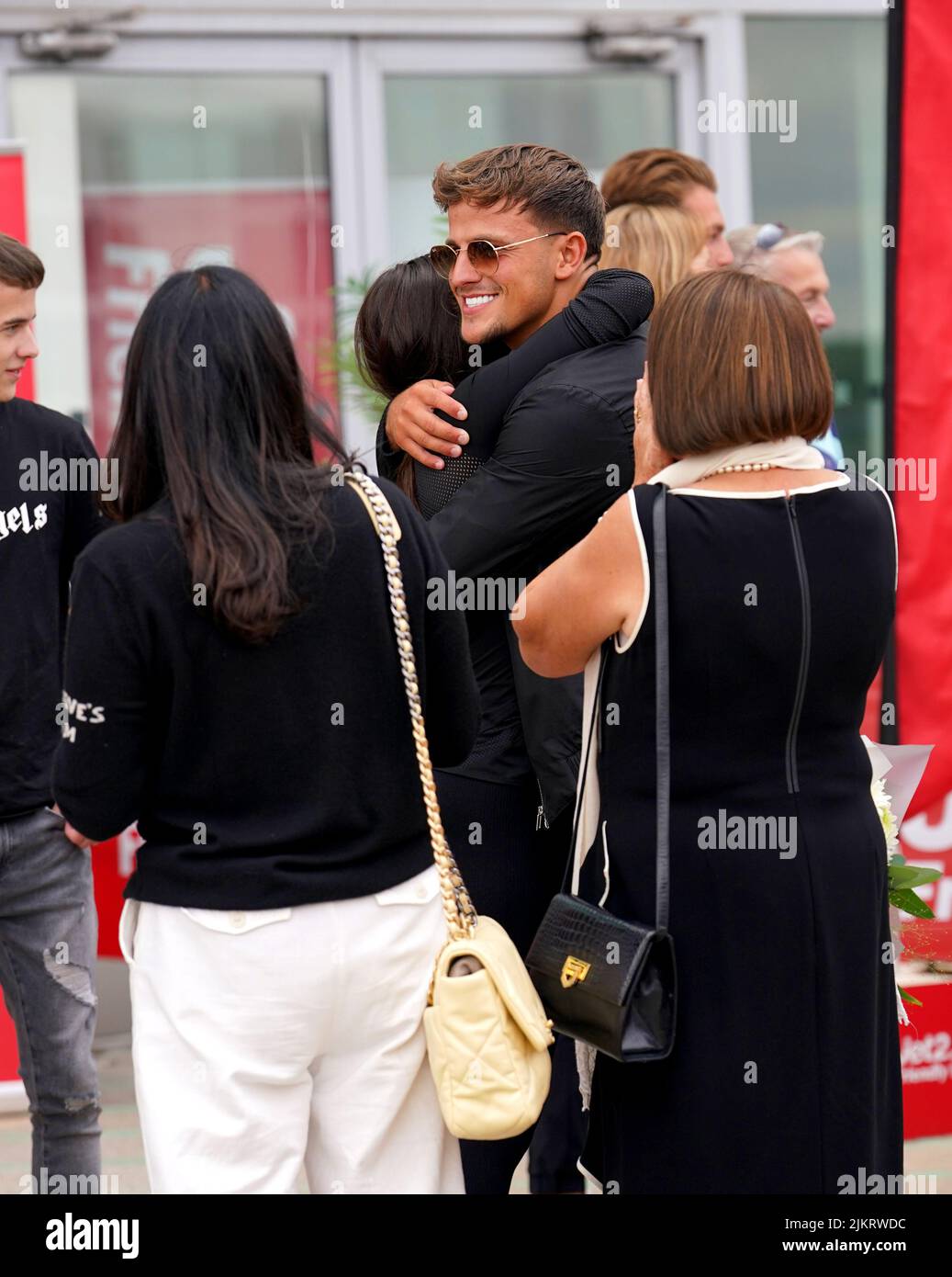 Love Island contestants Luca Bish and Gemma Owen hug as they arrive at Stansted Airport in Essex. Picture date: Wednesday August 3, 2022. Stock Photo