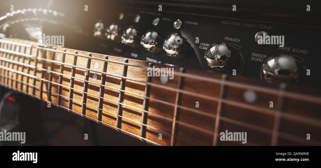 electric guitar neck and amplifier closeup in sound recording studio. rock music background. banner Stock Photo