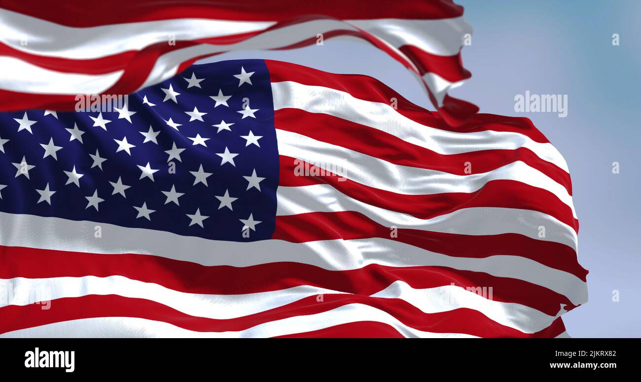 Flags of the United States of America waving in the wind. Clear sky in the background. Selective focus. Democracy, independence and election day. Patr Stock Photo