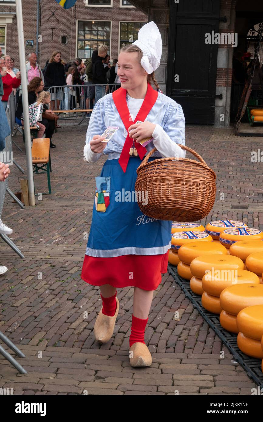 a beautiful lady in traditional costume with a basket full of cheese at the cheese market in alkmaar Stock Photo